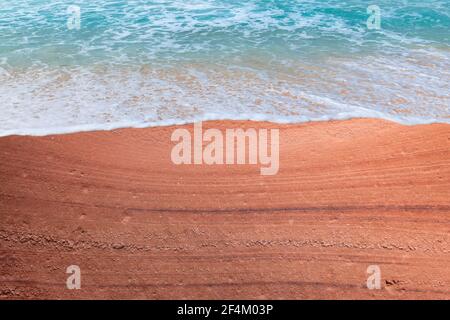Red stone beach and blue sea wave Stock Photo
