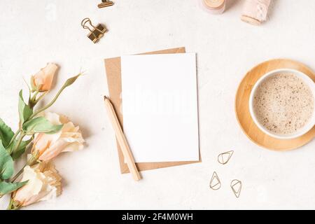 Blank white card with craft paper envelope in hands Stock Photo