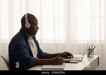 Mature african american freelancer working remotely with laptop at home office Stock Photo