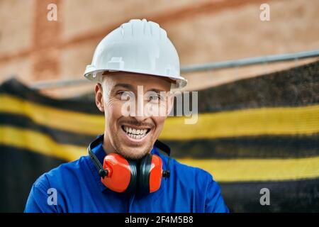 Young caucasian worker smiling happy wearing uniform at the city. Stock Photo