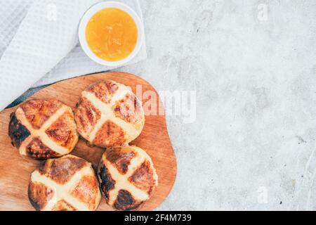 Traditional British Easter buns on a wooden plank. Stock Photo