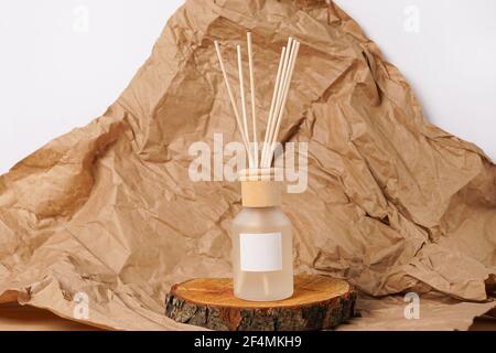 Aroma bottle glass and wooden sticks staying on wooden podium on the table with paper Stock Photo