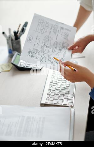 Hands of entrepreneurs discussing chart explaining new creative business idea Stock Photo