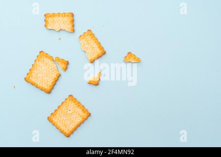 Broken dry cookies on blue background, top view, lay out Stock Photo