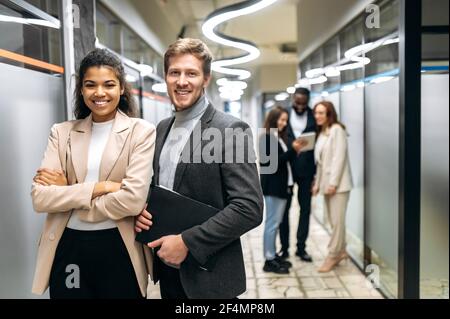 Portrait of successful stylish office employees at the workplace. Happy confident business people in formal wear looking directly at the camera, smiling, partnership concept Stock Photo