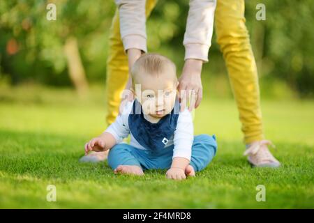 Cute five months old baby boy learning how to sit up without support. Baby during floortime. Adorable little child trying to sit up on his own. Stock Photo