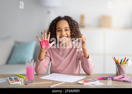 Girl painting with bright gouache paper floor Stock Photo - Alamy