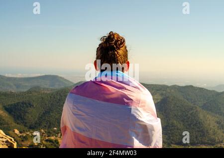 Young Long Hair  Man With Topknot Back Sitting at Mountains Canyon Looking to Horizon in Nature with Stock Photo