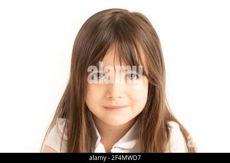 Little girl of five years old looking straight into the eyes on white background Stock Photo