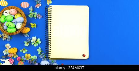 Easter greeting card concept with blank notebook, banner with blue bakcground and spring decoration Stock Photo