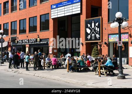 Ottawa, Canada - March 21, 2021: A crowd of people wait in line for a seat at the King Eddy in the Market as the weather turns nice and red zone Covid Stock Photo