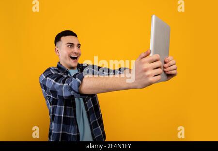 Shocked young guy looking at tablet screen in surprise, reading unbelievable news, cannot believe sale in online shop Stock Photo