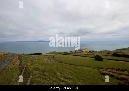 A view from Torr Head on the north Antrim coast looking over the Straits of Moyle towards the tip of the Mull of Kintyre in southwest Scotland which is a distance of 12 miles at its closest. A major transport connectivity review being led by Sir Peter Hendy is assessing the feasibility of a bridge or tunnel between Northern Ireland and Scotland. Stock Photo