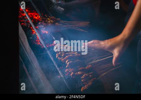 Chicken satay grill at a busy street food market Stock Photo