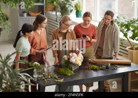 High angle view at diverse group of young people attending workshop on flower art Stock Photo