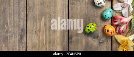 Banner with background from multi-colored flowers and painted eggs oden table. multicolored alstroemeria, pink, yellow, magenta, white and red Stock Photo
