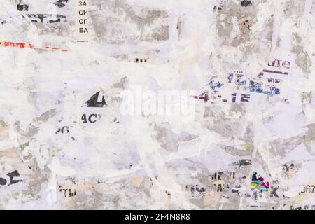 Old grunge ripped torn vintage collage street posters creased crumpled paper surface placard texture background backdrop Stock Photo