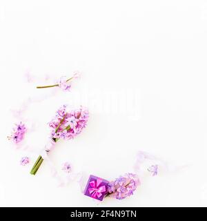 Floral bouquet of hyacinth flowers, petals with tapes and gift box on white background. Flat lay Stock Photo