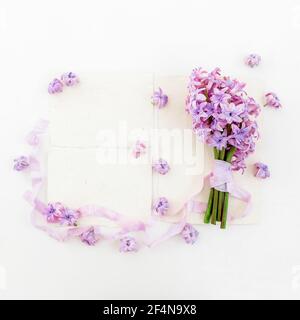 Floral bouquet of hyacinth flowers, petals with tapes and paer cards on white background. Flat lay, top view. Stock Photo
