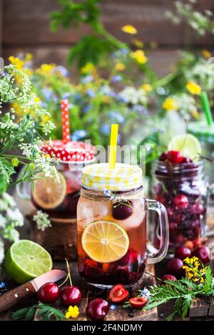 Healthy homemade cold lemonade with fresh berries and fruits in mason jar