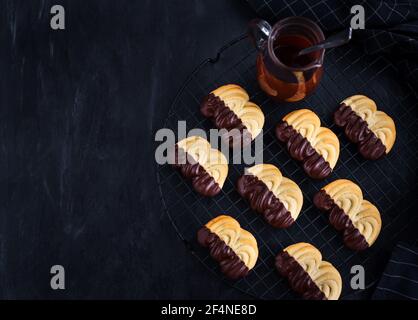 Homemade chocolate dipped shortbread cookies on dark background Stock Photo