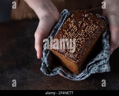 Traditional Russian rye Borodino bread. Female baker holds home made artisan organic bread fresh from . Homemade sourdough bread. Food preparation. Stock Photo