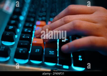 Multifunction keyboard with set of red keys and backlit. Employee uses a keyboard. WASD keys are used in many video games. Stock Photo