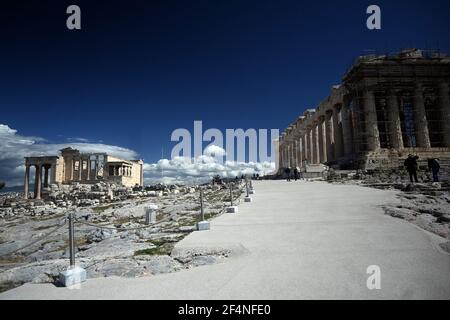 Athens, Greece. 22nd Mar., 2021. Visitors walk past the Temple of Parthenon on Acropolis Hill during the first day of the reopening of the archaeological sites, in Athens, Greece. ©Elias Verdi/Alamy Live News Stock Photo