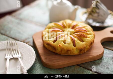 Homemade apple cake with teaware on shabby blue wooden background selective focus Stock Photo