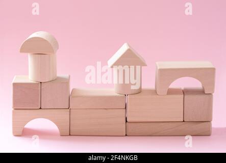 Abstract geometric real wooden cube with surreal layout on pink background Stock Photo