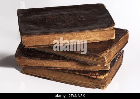 Stack of old worn out leather-bound books isolated on white background. Closeup Stock Photo