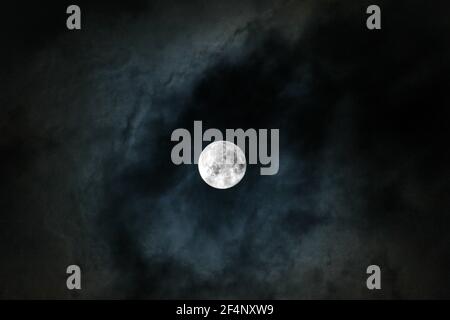 Full moon on cloudy winter night sky. Stock Photo