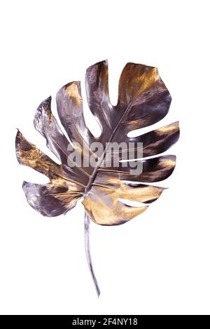 Monstera leaf painted in silver with gold flares isolated on white background. Minimalist luxury concept. Good for interior decoration pop-art poster. Stock Photo