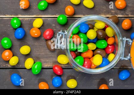 Creative colorful background.Chocolate bonbons balls in rustic wooden background.Colored sweets and candies concept Stock Photo