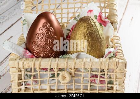 Closeup of two Easter eggs painted with edible paint on a basket of corn straw. Stock Photo