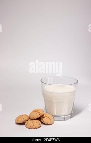 glass of milk near almond amaretti cookies isolated on white background. healthy breakfast snack. Stock Photo