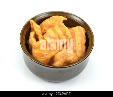 Bowl of bacon-flavored puffed wheat chips. Bacon Chips. Delicious bacon snacks isolated on white background. Pelleted salted snack bacon. Smoked bacon Stock Photo