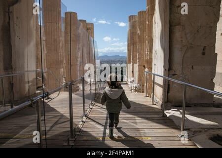 Athens, Greece. 22nd Mar, 2021. A child visits the archeological site of Acropolis in Athens, Greece, on March 22, 2021. On Monday, open-air archeological sites, including the Acropolis hill in Athens, reopened for the first time since the start of the lockdown. Only a small group of visitors is allowed to visit and the use of protective face masks is obligatory. Credit: Lefteris Partsalis/Xinhua/Alamy Live News Stock Photo