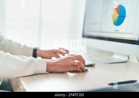 Finance asset manager using modern computer evaluating money growth. Home office, investing or freelance work on worldwide quarantine time concept Stock Photo