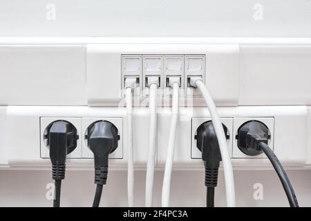 Installation of wires in electrical and local network sockets. Connecting and disconnecting computers in the office lan Stock Photo