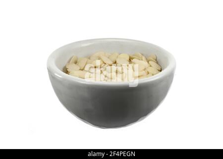 Blanched almonds flakes. Pile of peeled flaked almonds isolated on white. Stock Photo