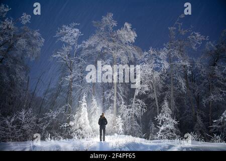 Silhouetted Hiker in Snowy Vermont Forest at Night Stock Photo