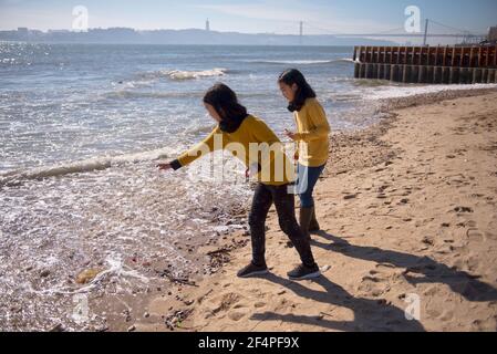 Two girls on the banks of the Teju River Throw stones into the river. Stock Photo