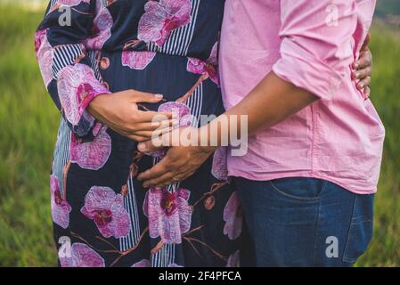 Couple expecting a baby. A man and a woman hold stomachs . Stock Photo