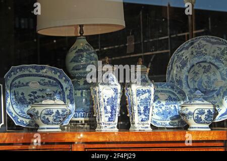 Blue and white pottery in the front window of an antique shop Stock Photo