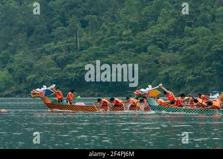 Hualien, Taiwan. 5th May, 2009. Dragon boat moves at full speed during racing in the rain across the Liyu Lake (Carp Lake) backdropped by the green vegetation of Liyushan (Carp Mountain), Dragon Boat Festival in Shoufeng Township, Hualien County, Taiwan. Stock Photo