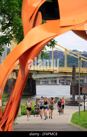 People exercising along Three River Heritage Trail in Allegheny Landing in North Shore with Roberto Clemente Bridge in the background.Pittsburgh.Pennsylvania.USA Stock Photo