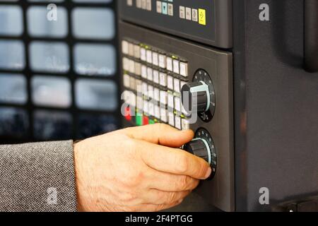 Engineer tunes parameters of CNC machine. CNC control panel closeup. Selective focus. Stock Photo