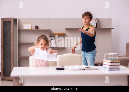 Teenager and his small sister staying at home during pandemic Stock Photo