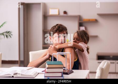 Teenager and his small sister staying at home during pandemic Stock Photo